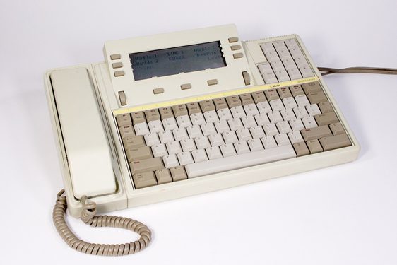 A cream telephone, with a receiver on one side and a keyboard on the other. A small screen sits above the keyboard.