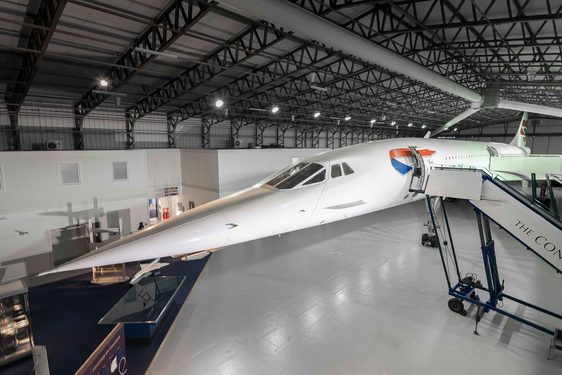 A view of the Concorde plane inside a hangar with its stairway doors open.