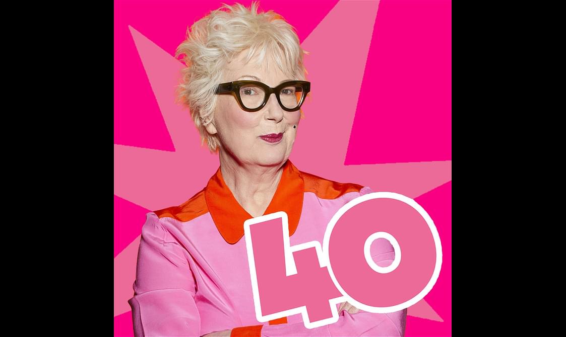 Jenny Eclair with short blonde hair and black glasses stands in front of a pink star graphic. The number 40 is in the foreground.