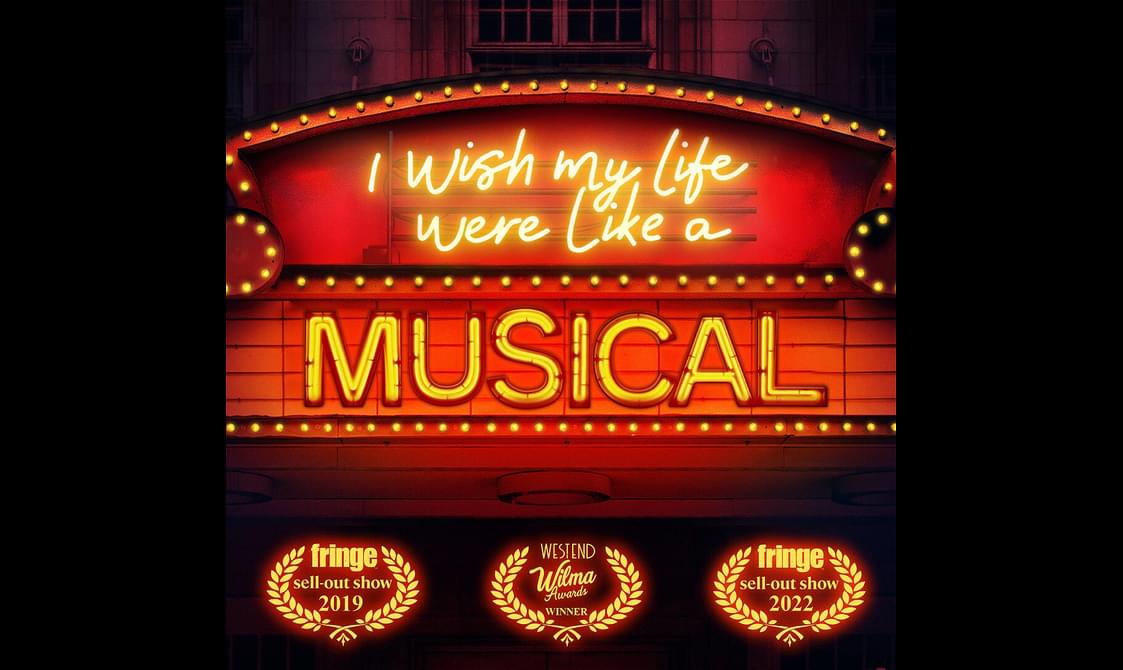 A red theatre sign lined with bright lights. The sign reads, "I wish my life were like a musical."