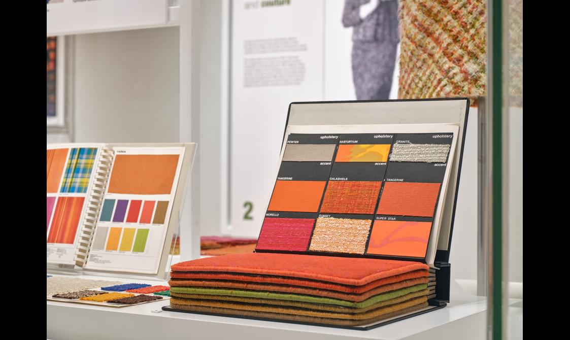 A book of orange coloured material samples.