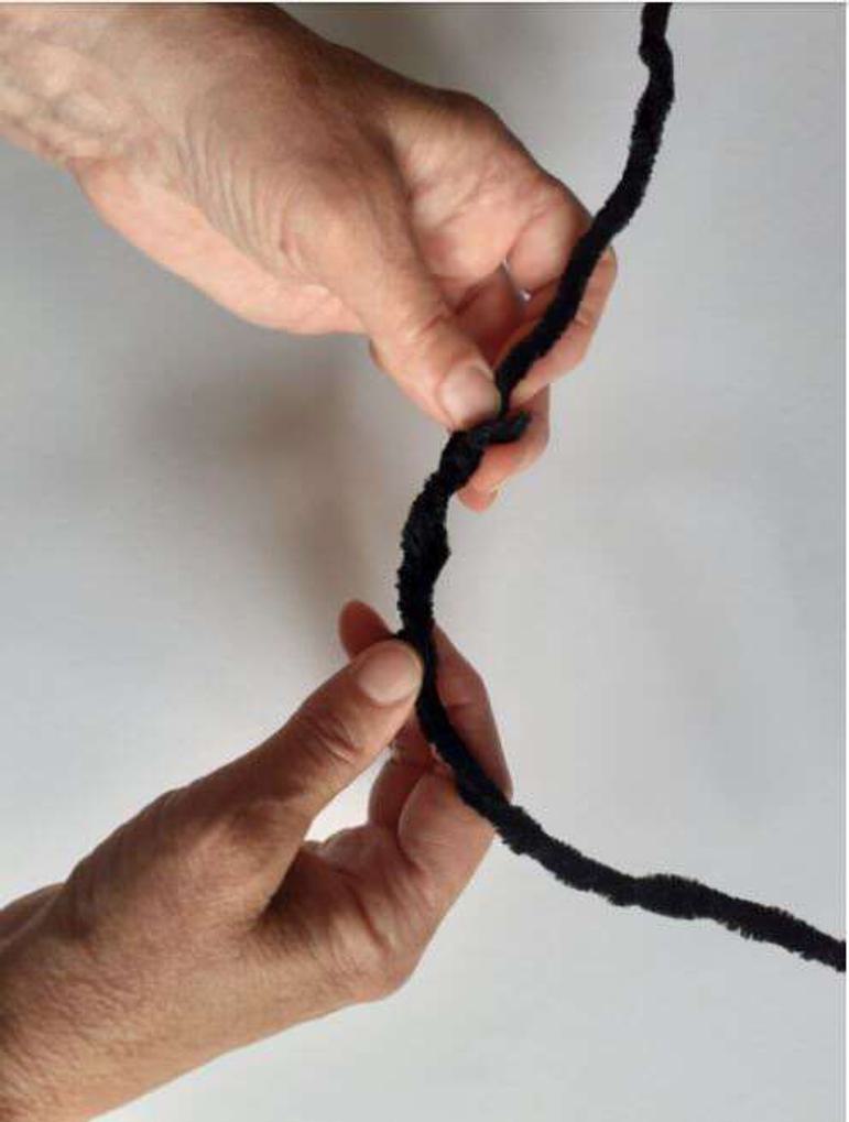 Two hands holding a curved black pipe cleaner.