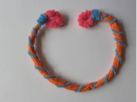 A handmade necklace crafted from colourful tissue paper and pipe cleaners.