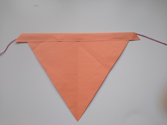 An orange paper bunting tied to a red string.